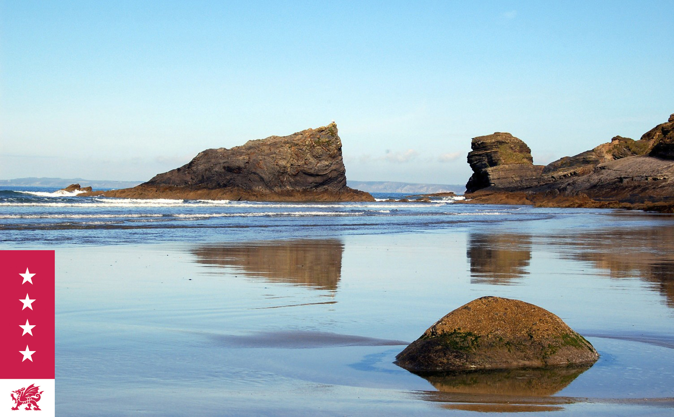 Coastal scene with rock formations reflected on a wet beach